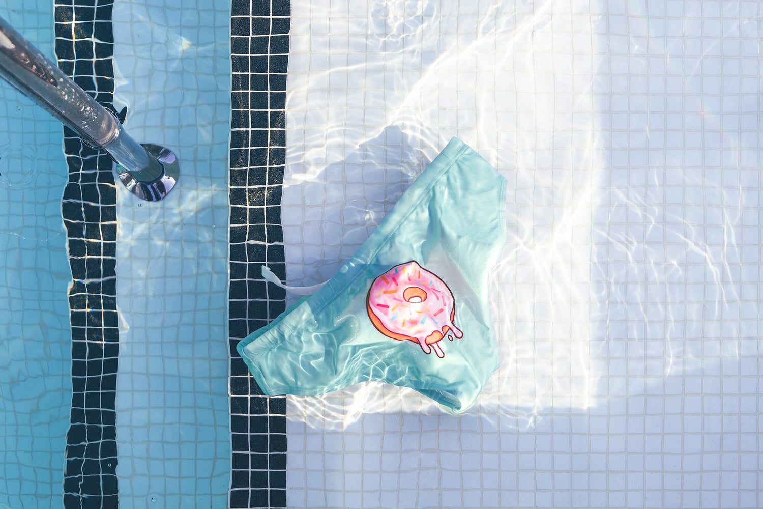 BOY'D Candy Swim Brief in mint green — playful hero shot styled with a donut